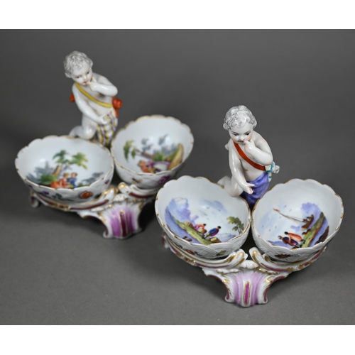 674 - Two 19th century Berlin porcelain double salts, modelled as putti, their baskets painted with courti... 