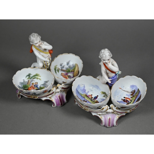 674 - Two 19th century Berlin porcelain double salts, modelled as putti, their baskets painted with courti... 