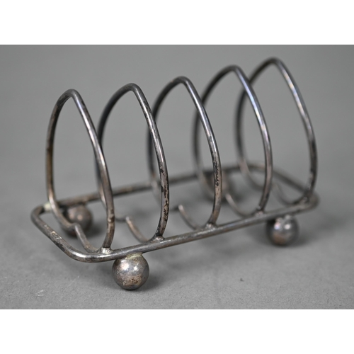 85 - A matched pair of silver baluster peppers, Tessiers Ltd, London 1950, to/w a small silver toast-rack... 