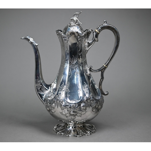 94 - A Victorian silver coffee pot with falcon finial and engraved decoration, the scroll handle with ivo... 