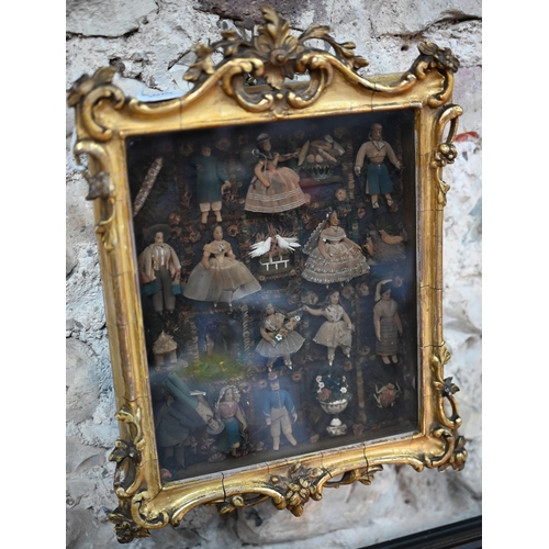 1020 - A 19th century Continental diorama with miniature fabric costume figures in garden setting, in glaze... 