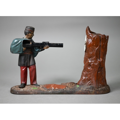 1060 - An antique novelty cold-painted iron money-box, cast as a soldier aiming at a tree