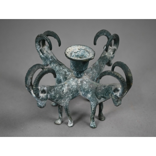 1099 - A verdigris-patinated candlestick supported by four goats, in the antique manner, 11 cm high