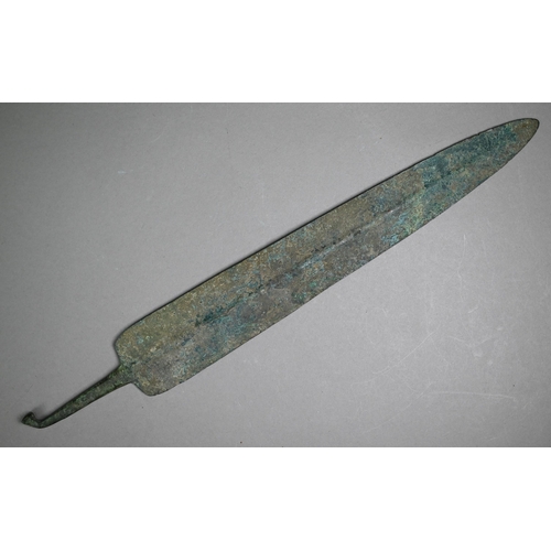 1104 - A Bronze Age shortsword blade of broad fin form with raised midrib, the tang with wrought turn-over ... 