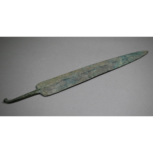 1104 - A Bronze Age shortsword blade of broad fin form with raised midrib, the tang with wrought turn-over ... 