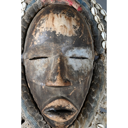 1112 - A West African Dan tribe mask, Deangle, Ivory Coast or Liberia, the carved oval stained hardwood fac... 