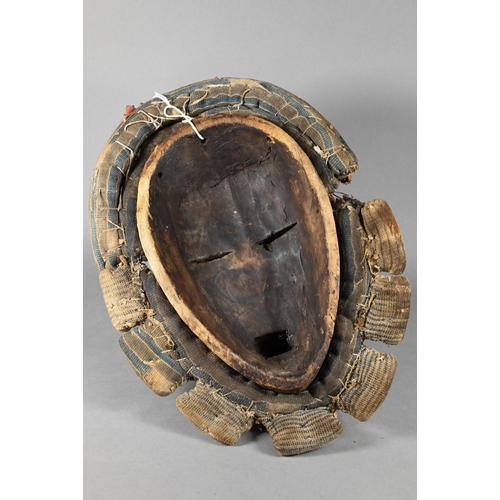 1112 - A West African Dan tribe mask, Deangle, Ivory Coast or Liberia, the carved oval stained hardwood fac... 