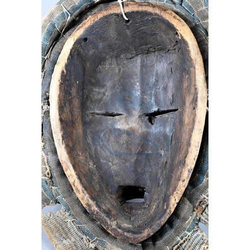 1112 - A West African Dan tribe mask, Deangle, Ivory Coast or Liberia, the carved oval stained hardwood fac... 