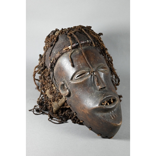 1112 - A West African Dan tribe mask, Deangle, Ivory Coast or Liberia, the carved oval stained hardwood fac... 