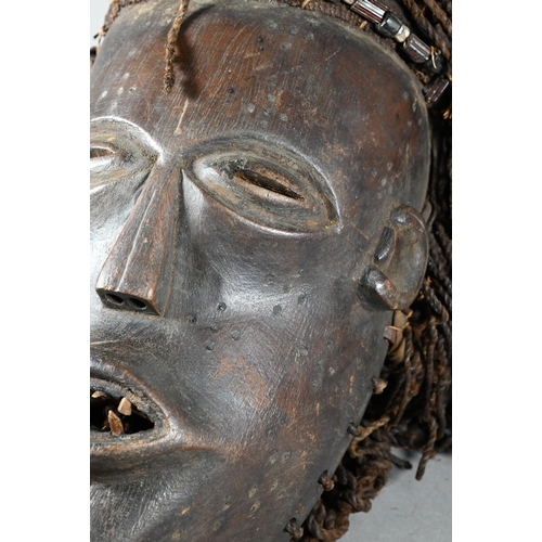 1112 - A West African Dan tribe mask, Deangle, Ivory Coast or Liberia, the carved oval stained hardwood fac... 