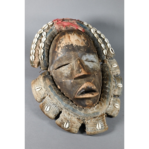 1112 - A West African Dan tribe mask, Deangle, Ivory Coast or Liberia, the carved oval stained hardwood fac... 