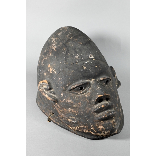 1115A - A 20th century stained and carved wood African tribal helmet mask, 32 cm