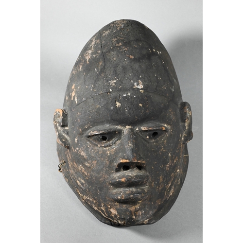 1115A - A 20th century stained and carved wood African tribal helmet mask, 32 cm