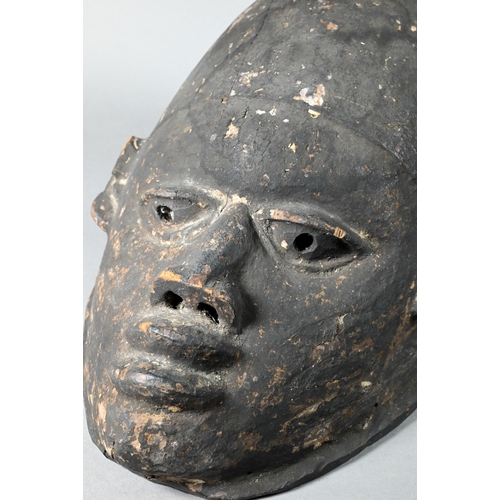 1115A - A 20th century stained and carved wood African tribal helmet mask, 32 cm