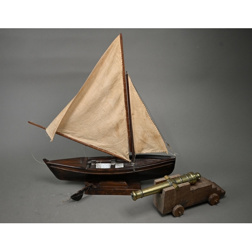 1179 - A model sailing dinghy, with card inscribed 'Model of Malay 'Dukone' made by Dick the Malay Pilot, C... 