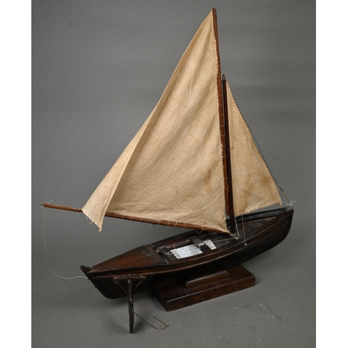 1179 - A model sailing dinghy, with card inscribed 'Model of Malay 'Dukone' made by Dick the Malay Pilot, C... 