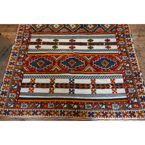 1209 - A Mid-Century Moroccan kelim panelled rug of multi-coloured geometric symbols on predominantly camel... 