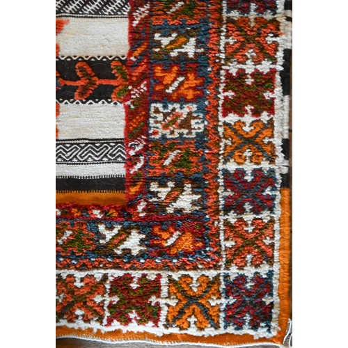 1209 - A Mid-Century Moroccan kelim panelled rug of multi-coloured geometric symbols on predominantly camel... 