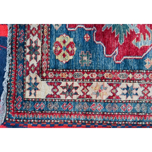 1211 - A contemporary Kazak rug, triple lozenge design on mid blue/red ground, 190 x 118 cm