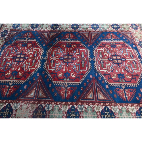 1216 - An old Turkish Caucasian design carpet  blue ground with three red ground lozenges with conforming w... 