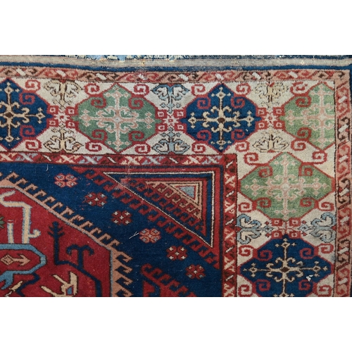 1216 - An old Turkish Caucasian design carpet  blue ground with three red ground lozenges with conforming w... 