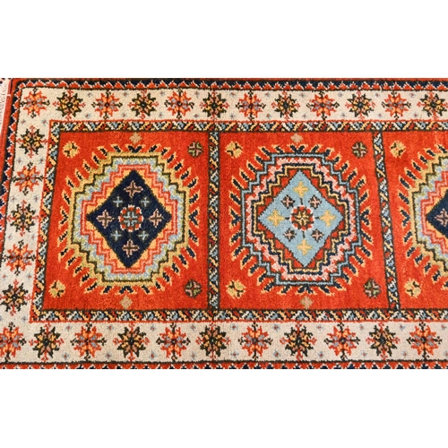 1218 - A contemporary Indo-Persian Kazak runner, burnt orange ground with five alternating lozenge design, ... 