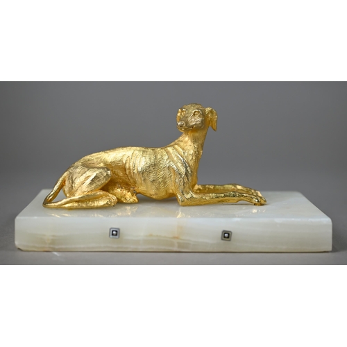 1246 - A gilt metal recumbant lurcher, on onyx base, 18 cm wide overall