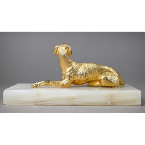 1246 - A gilt metal recumbant lurcher, on onyx base, 18 cm wide overall