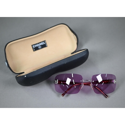 1275 - A cased pair of Chanel sunglasses with amethyst-shaded lenses