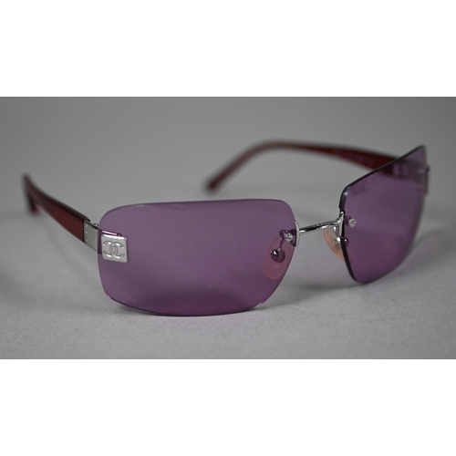 1275 - A cased pair of Chanel sunglasses with amethyst-shaded lenses