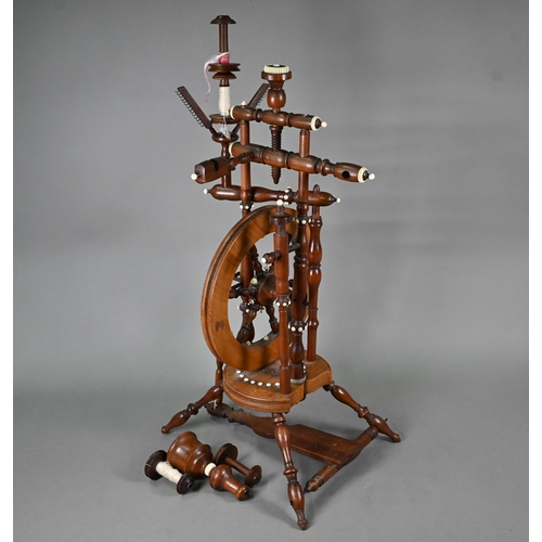 832 - An antique turned wood small spinning wheel with bone-mounts, 73 cm overall