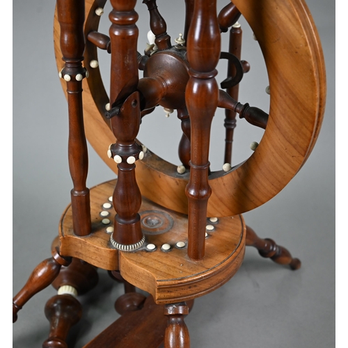 832 - An antique turned wood small spinning wheel with bone-mounts, 73 cm overall