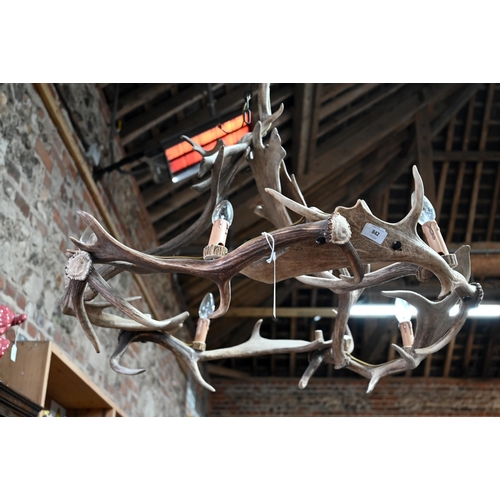 842 - A large deer antler ceiling electrolier formed by linked antlers, fitted with five bulbs, approx. 80... 