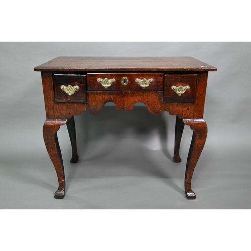 848 - An 18th century oak three drawer side table with fret cut apron raised on four square cabriole legs,... 