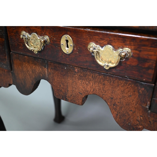 848 - An 18th century oak three drawer side table with fret cut apron raised on four square cabriole legs,... 