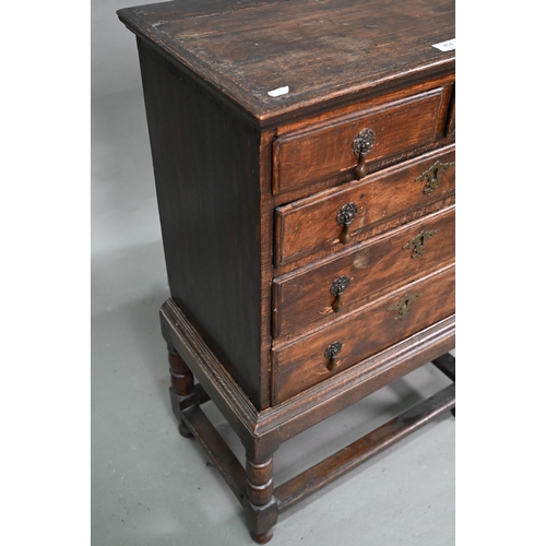 853 - A diminutive George II country oak chest on stand, with two short over three long graduated drawers,... 