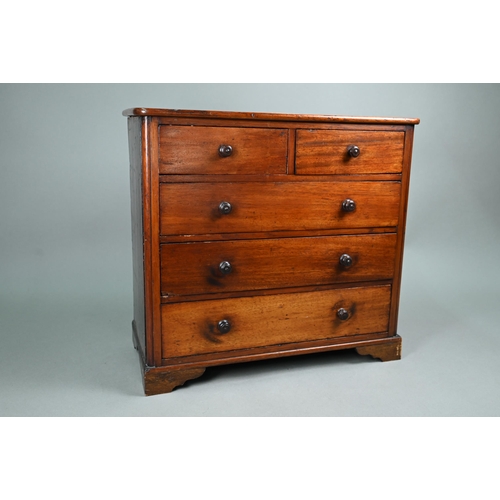 878 - An old miniature mahogany chest of two short over three long graduated drawers, with turned pulls, o... 