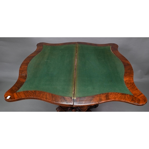 881 - A Victorian walnut card table, the fold over serpentine top with baize lining, raise on moulded clus... 