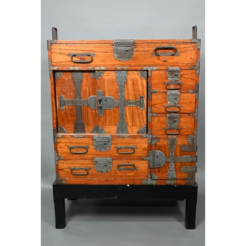 888 - An antique Japanese steel bound softwood ledger chest, with an arrangement of drawers around a slide... 