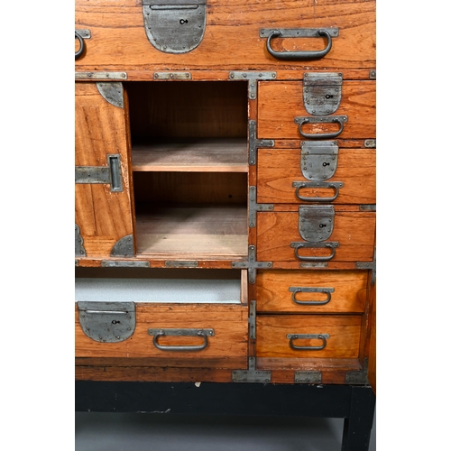 888 - An antique Japanese steel bound softwood ledger chest, with an arrangement of drawers around a slide... 