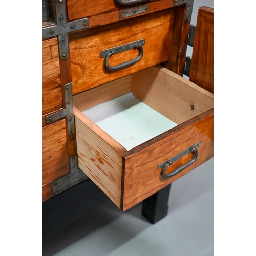 888 - An antique Japanese steel bound softwood ledger chest, with an arrangement of drawers around a slide... 