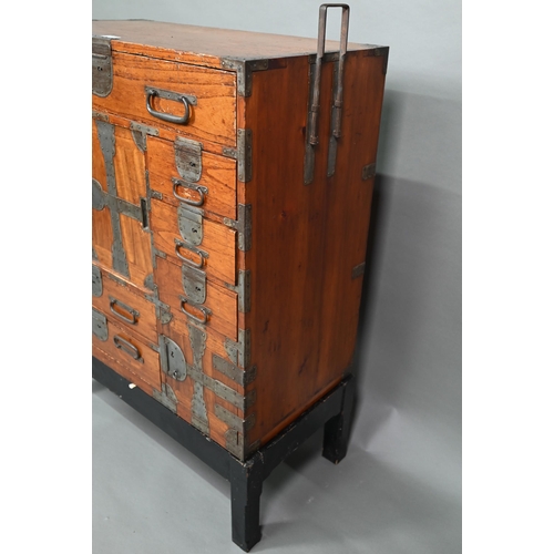 888 - An antique Japanese steel bound softwood ledger chest, with an arrangement of drawers around a slide... 