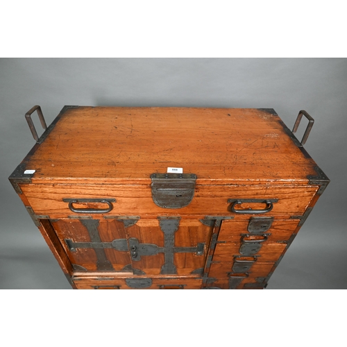 888 - An antique Japanese steel bound softwood ledger chest, with an arrangement of drawers around a slide... 