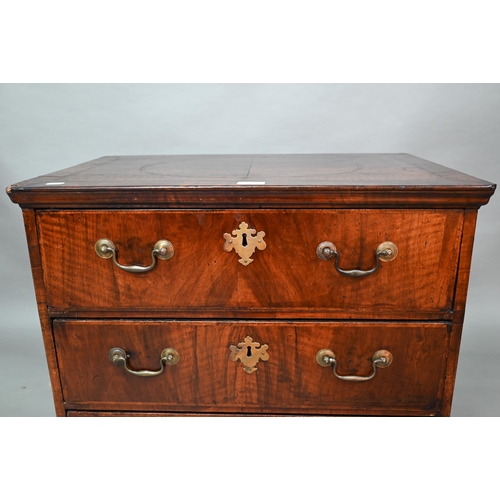 892 - A small Georgian cross-banded mahogany chest of three long drawers, raised on shaped bracket, 68 cm ... 