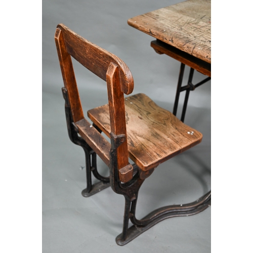 894 - A Victorian cast iron and oak student/school desk, the slope top carved with multiple graffiti, rais... 