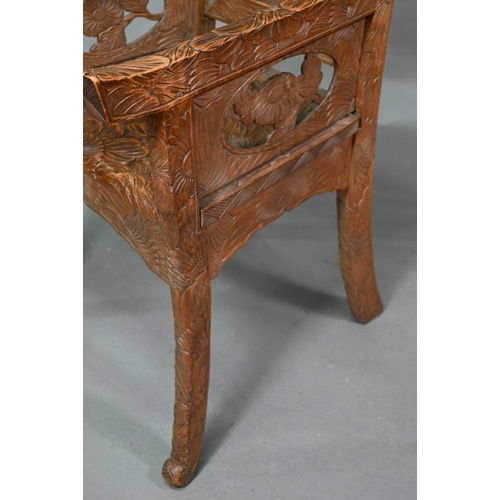 897 - A Japanese Arts & Crafts Liberty armchair, constructed in sections and carved with sunflowers