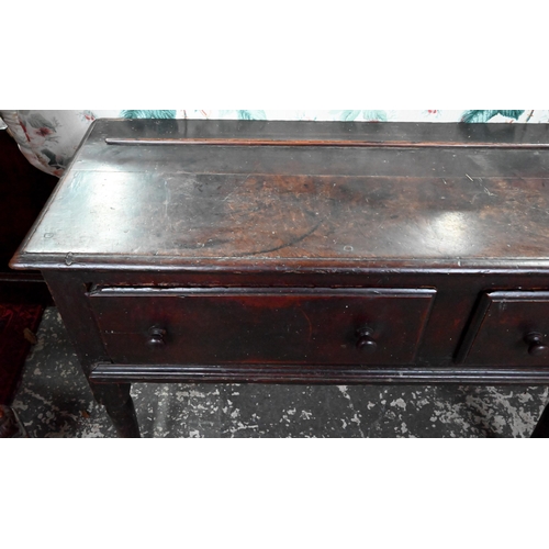 901 - An 18th century oak three drawer low dresser, very dark surface finish, raised on three turned front... 