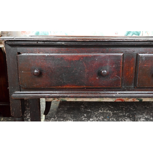 901 - An 18th century oak three drawer low dresser, very dark surface finish, raised on three turned front... 