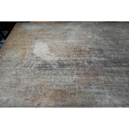 908 - An antique oak refectory table, the wide four plank top over a plain frieze and joint frame with tur... 