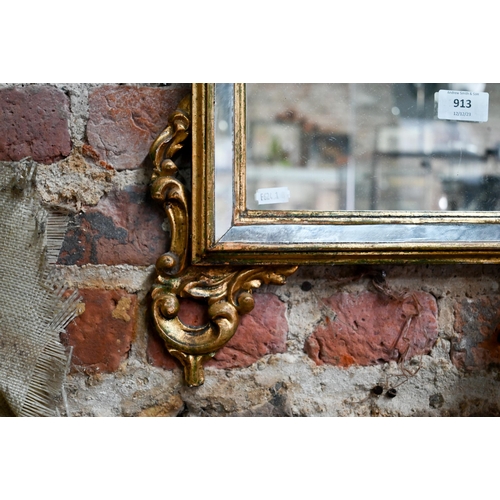 913 - A 19th century Italian gilt framed cushion mirror edged wall mirror, 93 cm h x 51 cm w